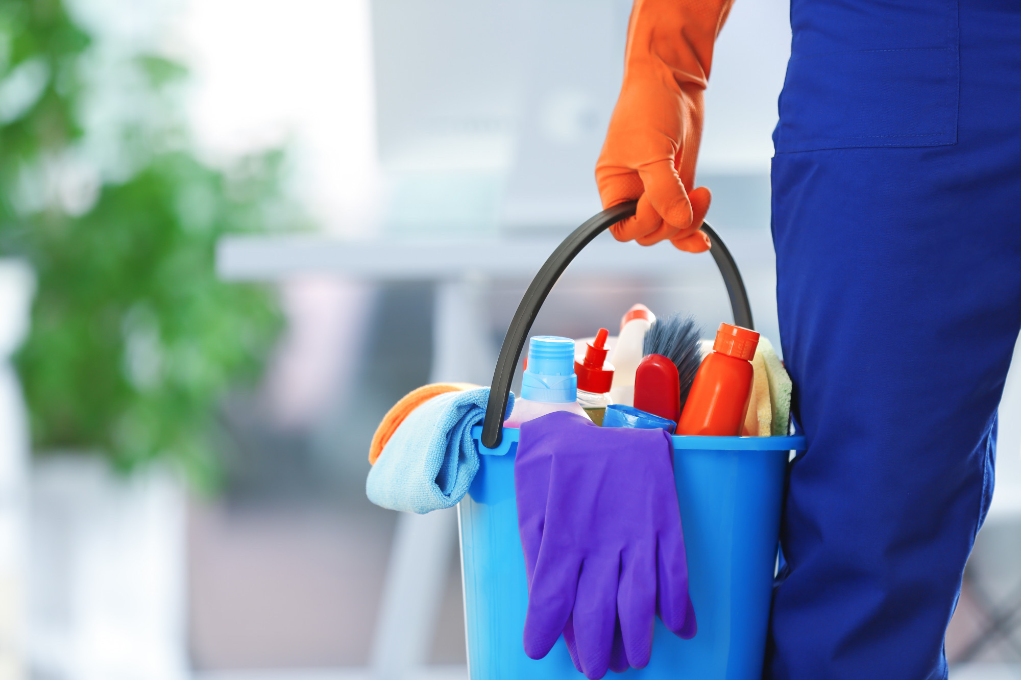 holding cleaning products and tools on bucket, close up